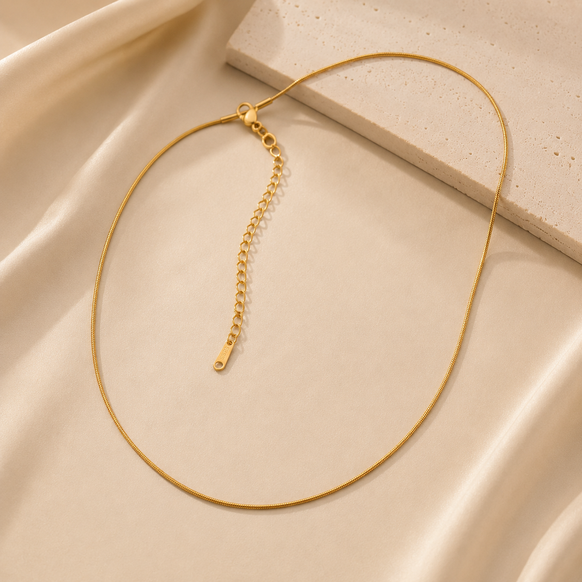 Gold necklace on a beige fabric background